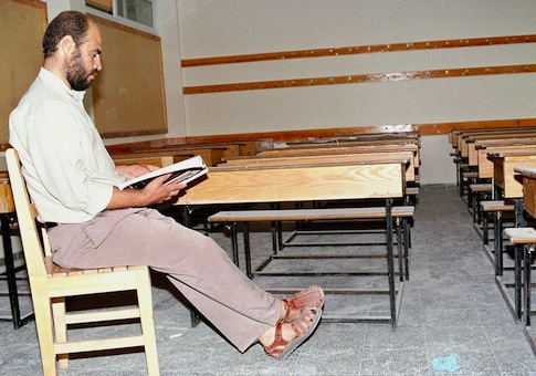 A Palestinian teacher reads a book in his empty classroom at the Ebn Sena Element School in Rafah Refugee camp in Gaza Strip