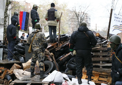 Pro-Russian men stand guard at a barricade near the police headquarters in Slaviansk
