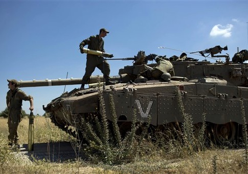 Israeli soldiers load shells in their tank following the first death on the Israeli side of the Golan since the Syrian civil war erupted more than three years ago