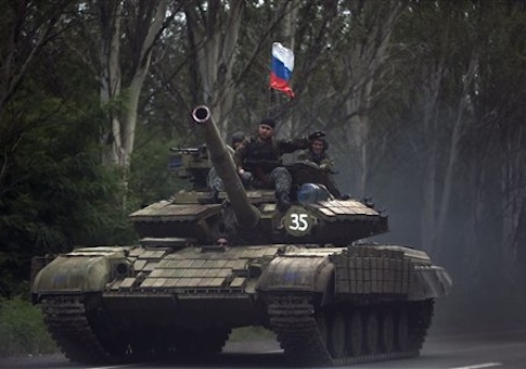 Pro-Russian rebels ride on a tank flying Russia's flag, on a road east of Donetsk