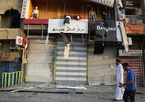 Residents inspect the site of bomb attack at a market in Baghdad's Sadr City