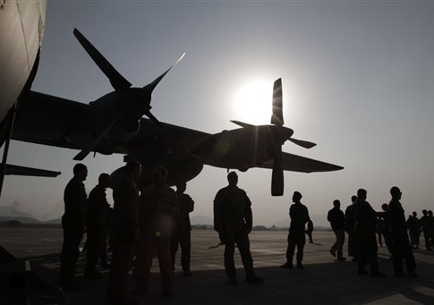 Afghan National Army and International Security Assistance Force personnel gather near a C-130 transport aircraft during a handover ceremony at the Afghan Air Force Base in Kabul