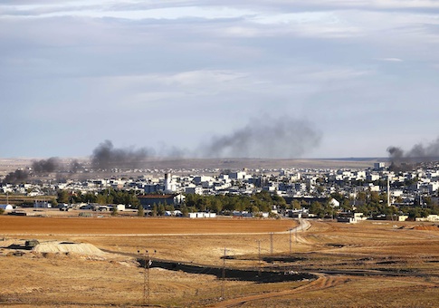 Smoke rises from the Syrian town of Kobani, seen from near the Mursitpinar crossing on the Turkish-Syrian border in the southeastern town of Suruc in Sanliurfa province, October 20,