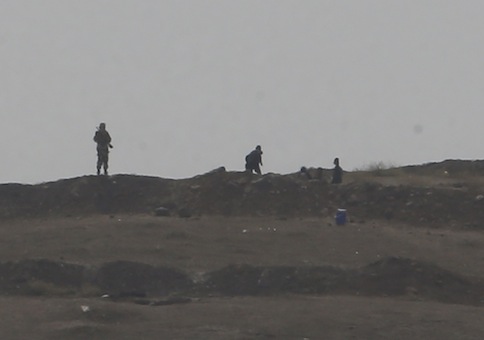 Armed men, presumed by local sources to be Islamic State fighters, are pictured at a checkpoint in the west of Syrian town of Kobani