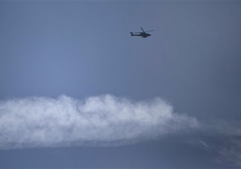An Israeli helicopter flies over the Israel-Lebanon border, Wednesday, Jan. 28, 2015