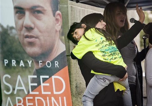 Nagmeh Abedini holds her daugher Rebekka Grace Abedini, 7, during a prayer vigil at the Idaho Statehouse in Boise Thursday Sept. 26, 2013