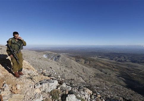 An Israeli soldier speaks on his mobile phone at a military outpost at Mount Hermon in the Israeli-controlled Golan Heights overlooking the Israel-Syria border on Wednesday, Feb. 4, 2015