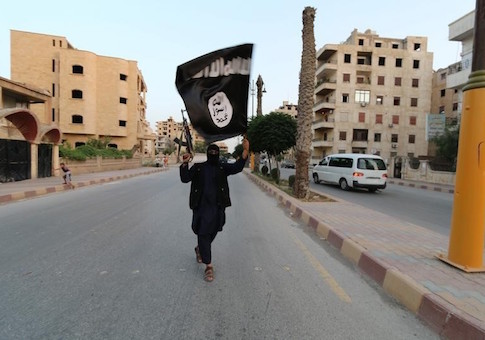 A member loyal to the Islamic State in Iraq and the Levant (ISIL) waves an ISIL flag in Raqqa
