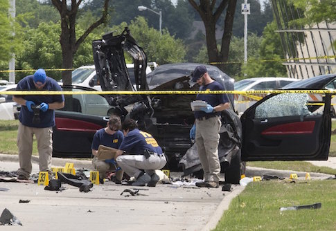 Local police and FBI investigators survey the scene where two gunmen were shot dead, after their bodies were removed in Garland