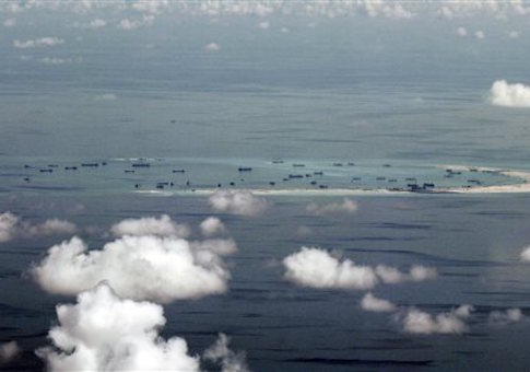 This areal photo taken through a glass window of a military plane shows China's alleged on-going reclamation of Mischief Reef in the Spratly Islands in the South China Sea Monday, May 11