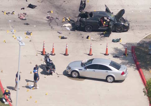 The area around a car that was used the previous night by two gunmen is investigated by local police and the FBI in Garland