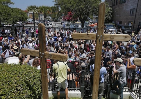 Mourners raise hands outside Morris Brown AME Church for a vigil the day after a mass shooting in Charleston