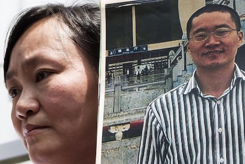 Wang, wife of Chinese human rights lawyer Tang Jingling, holds his portrait during a protest in Hong Kong