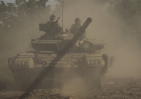 A Russia-backed rebel tank moves to position, near Donetsk airport, eastern Ukraine, Friday, June 12