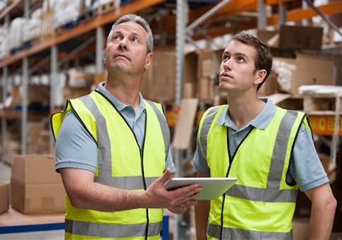 Men in warehouse using digital tablet