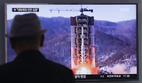 A man watches a TV news program showing a file footage of North Korea's rocket launch at Seoul Railway Station in Seoul