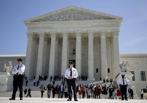 Immigration activists join hands after the U.S. Supreme Court heard arguments over the constitutionality of President Obama's executive action to defer deportation of certain immigrants, in Washington