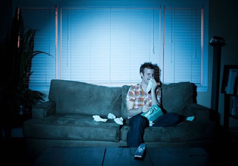 Young man watching tv, crying