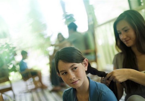 mother braids daughter's hair
