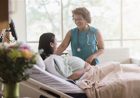Doctor talking to pregnant patient in hospital room