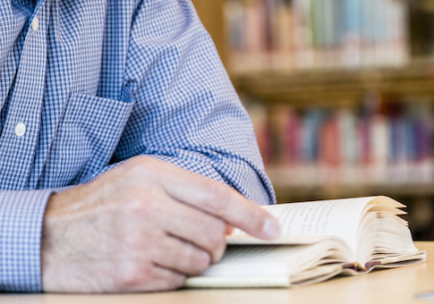 Caucasian man reading book in library