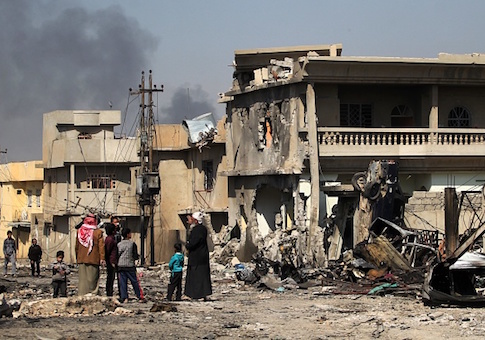Iraqis stand outside the rubble of their homes in the Shuhada neighbourhood of west Mosul