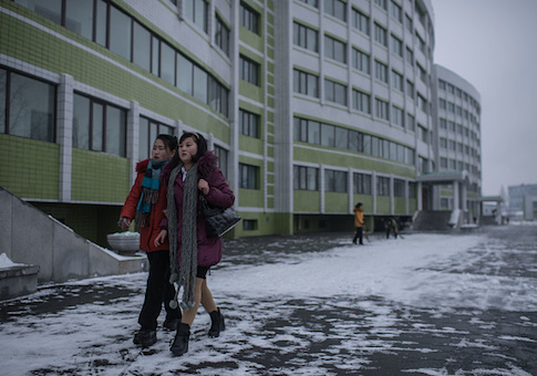 Two women walk outside a dormitory of the Kim Jong-Suk textile mill in Pyongyang