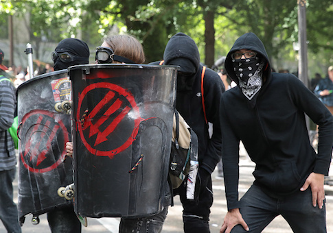 Police clash with demonstrators as they try to clear 'Antifa' members and anti-Trump protesters from the area during a protest in Portland