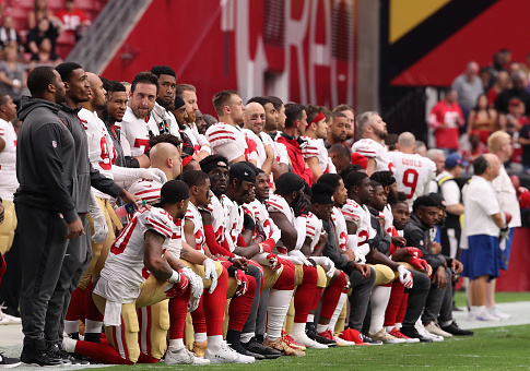 Members of the San Francisco 49ers kneel for the National Anthem / Getty Images