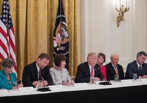 President Donald Trump is flanked by GOP senators to discuss health care