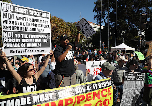 Protesters hold signs during a free speech rally
