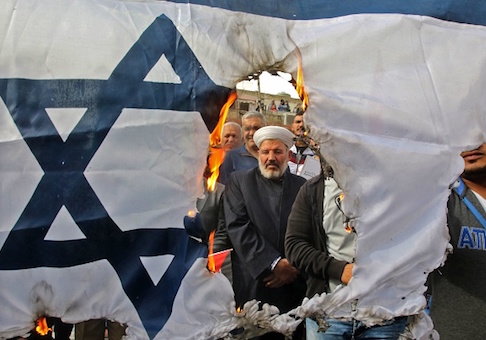 Protesters burn an Israeli flag during a demonstration organized by Hezbollah