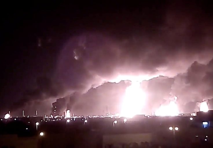 Fires burn in the distance after a drone strike by Yemen's Iran-aligned Houthi group on Saudi company Aramco's oil processing facilities, in Buqayq, Saudi Arabia
